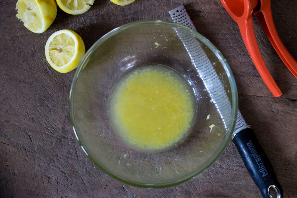lemon juice and zest in a bowl on a wooden board