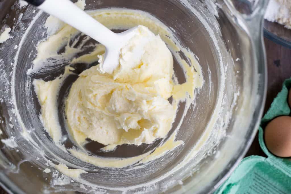Glass mixing bowl filled with creamed butter and sugar