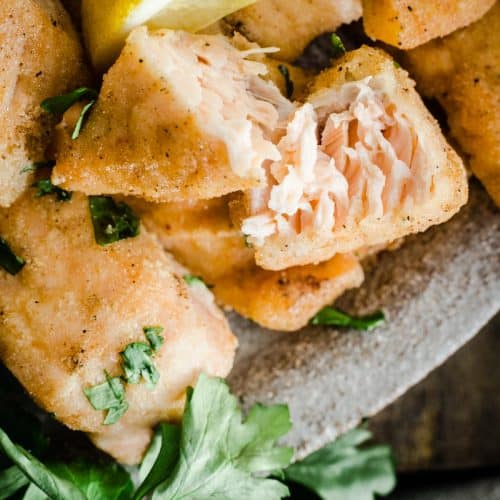 Close up of salmon nugget broken apart on a plate