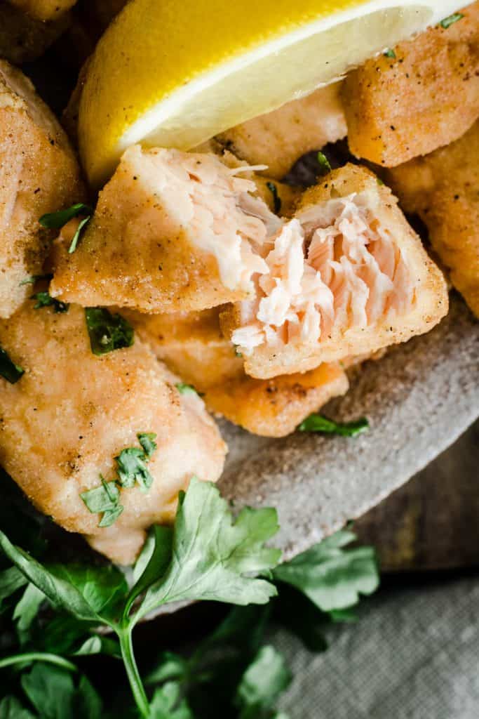 Close up of salmon nugget broken apart on a plate