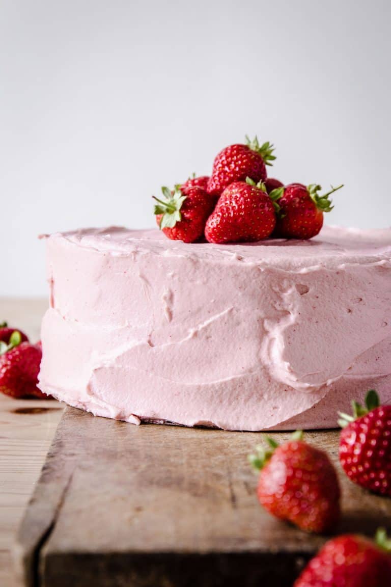 strawberry cake on wooden board surrounded by strawberries