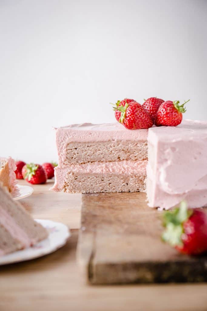strawberry cake on wooden board surrounded by strawberries