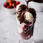 Ice Cream in a sundae glass with hot chocolate sauce being dripped over the top
