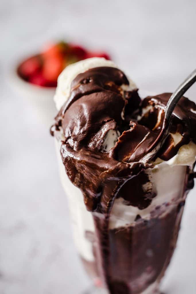 Ice Cream in a sundae glass covered in hot chocolate sauce