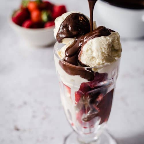 Ice Cream in a sundae glass with hot chocolate sauce being dripped over the top