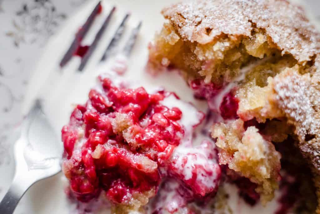 close up of raspberry pudding and cream