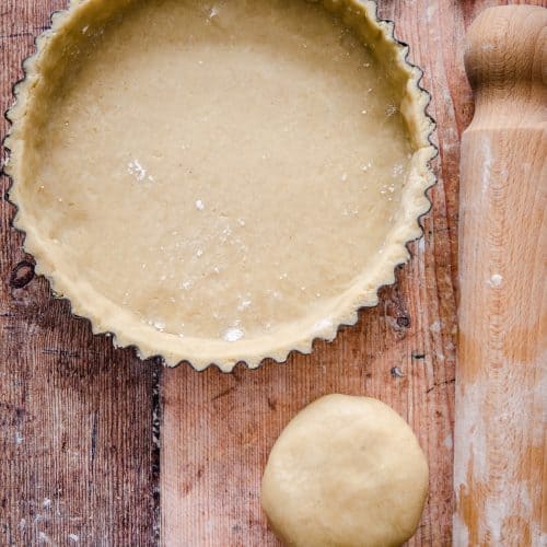 tart tin with pastry case, wooden spoon on the side