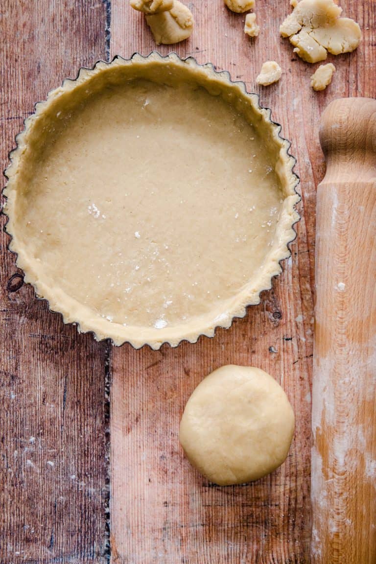 tart tin with pastry case, wooden spoon on the side