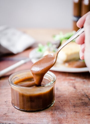 spoon dipping into a pot of homemade brown sauce