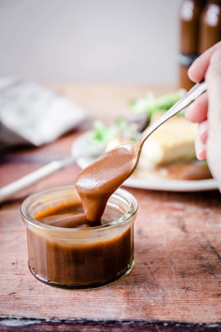 spoon dipping into a pot of homemade brown sauce