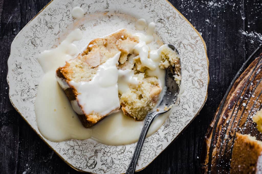 slice of apple cake on a plate with custard