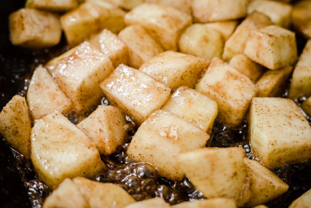 Cubes of apple caramelising in a pan