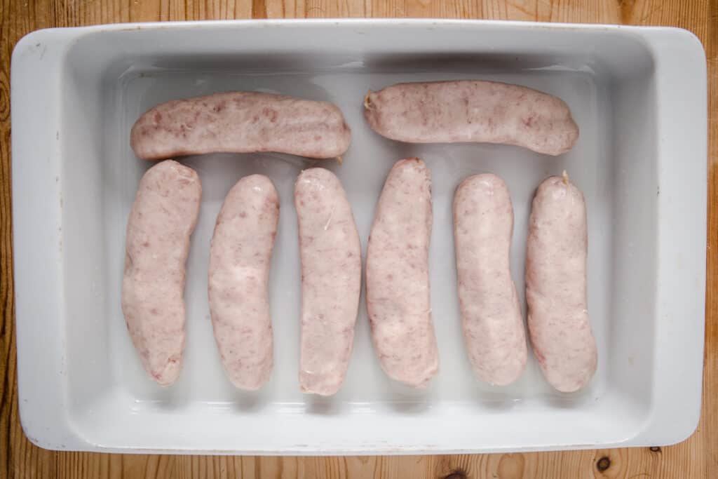 Sausages arranged neatly in a roasting dish