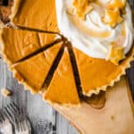 overhead image of pumpkin pie with slices cut out