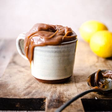 Lemon caramel in a mug with some lemons behind