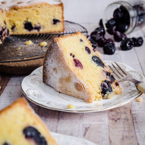 Cherry Cake sliced on a plate in front of whole cake