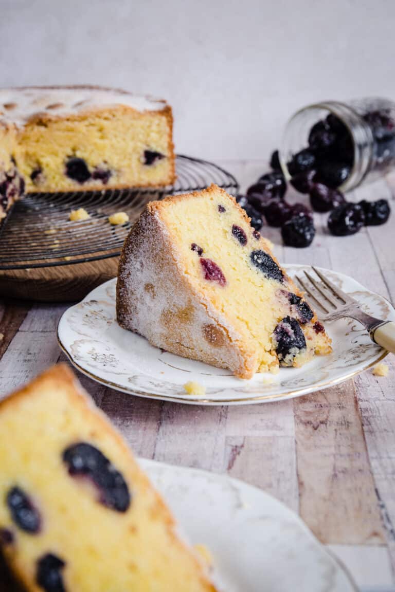 Cherry Cake sliced on a plate in front of whole cake