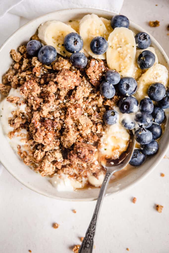 bowl of granola with blueberries, bananas and spoon