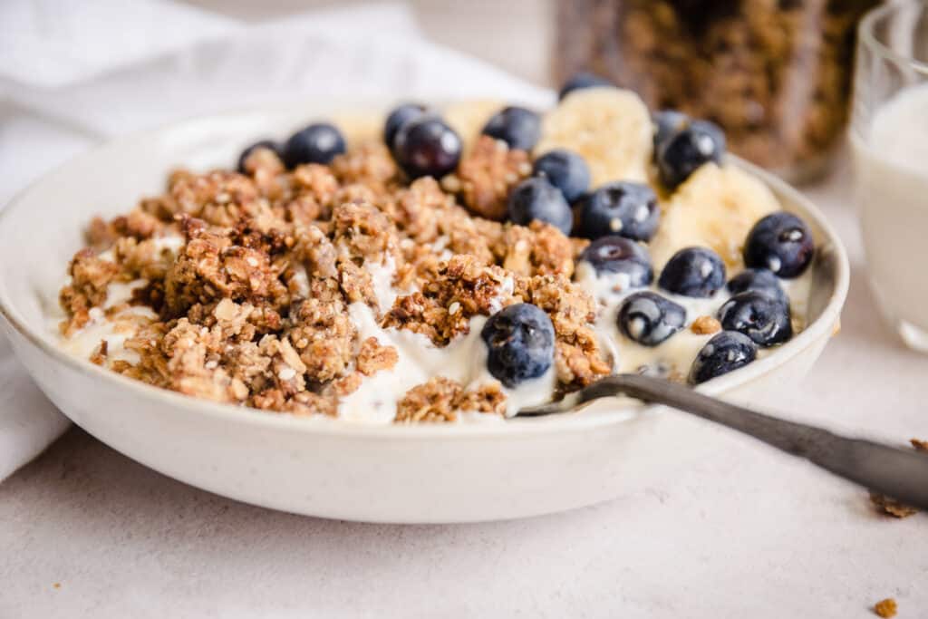 bowl of granola with blueberries, bananas and spoon