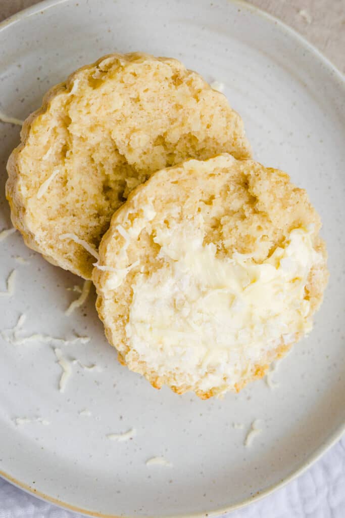 halved scone on a plate with butter