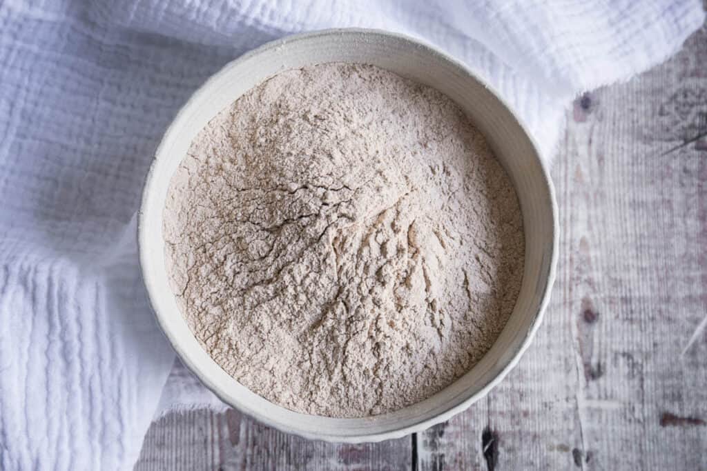 bowl of green banana flour on a table with a cloth