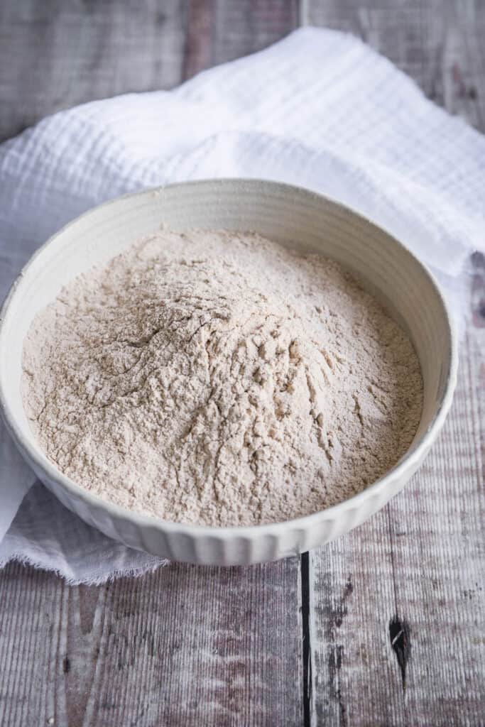 bowl of green banana flour on a table with a cloth