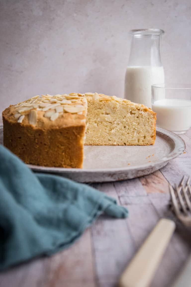 pear and almond cake on plate on table with cloth, cutlery and milk