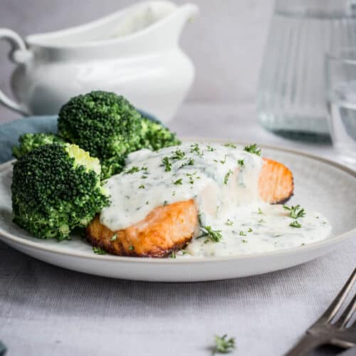 Parsley sauce drizzled over salmon and broccoli on a plate