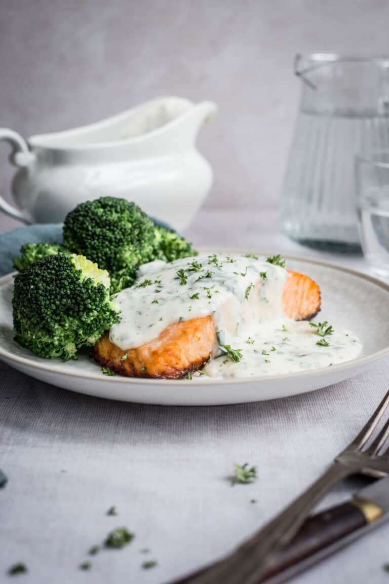 Parsley sauce drizzled over salmon and broccoli on a plate