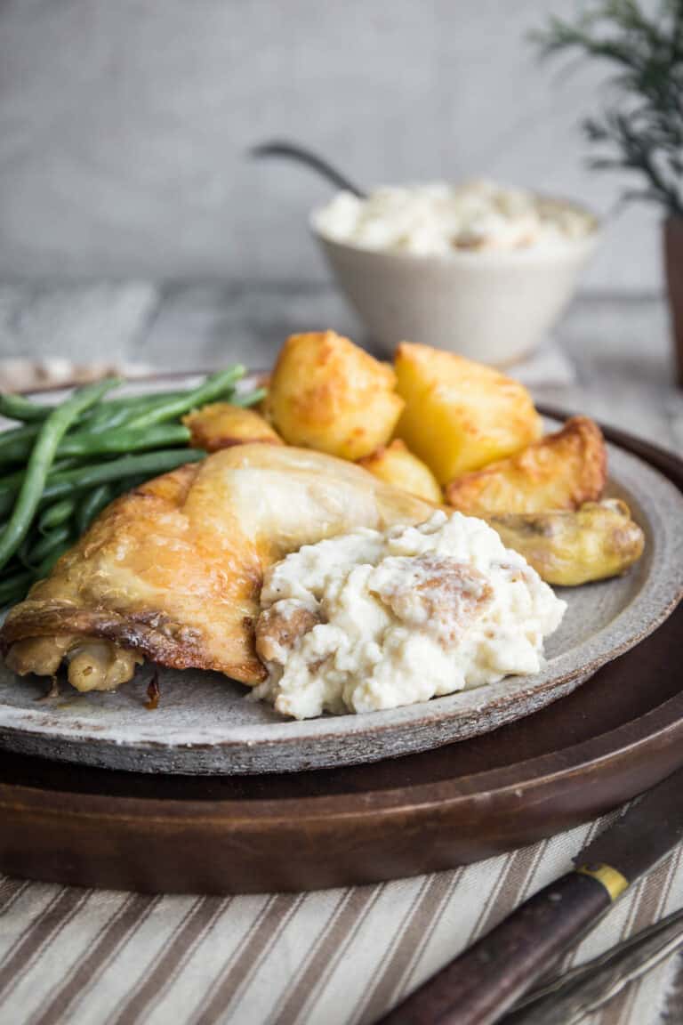 Plate of bread sauce accompanying roast chicken and vegetables. Next to bowl of bread sauce.