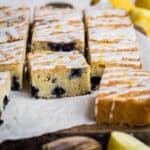 Slices of Gluten Free Lemon Drizzle Traybake with Blueberries on a wooden board
