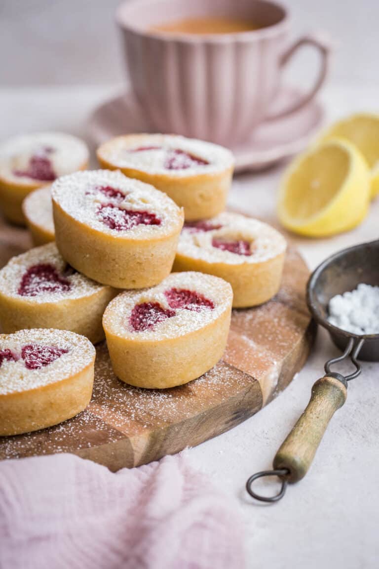 lemon raspberry friands stacked on a wooden board