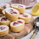 lemon raspberry friands stacked on a wooden board