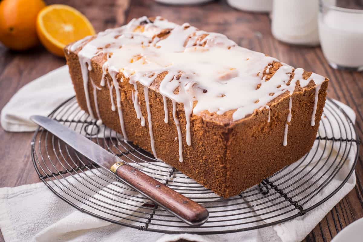 Orange Drizzle Cake on a wire rack next to knife