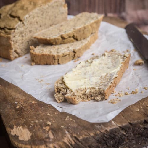 Slice of soda bread slathered with butter and a bite taken out.