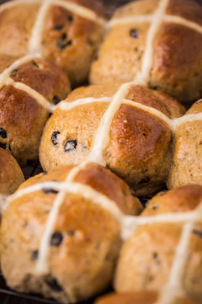 Hot Cross Buns closely packed together fresh from the oven.