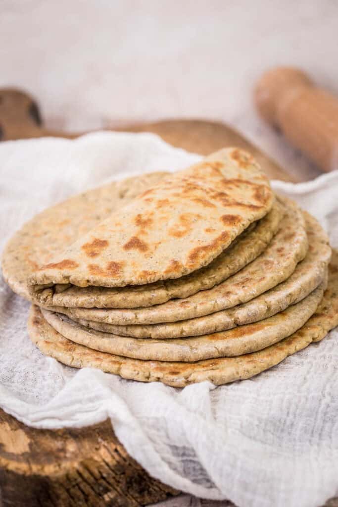 A pile of Gluten-Free Flatbreads. The top one is softly folded in half.