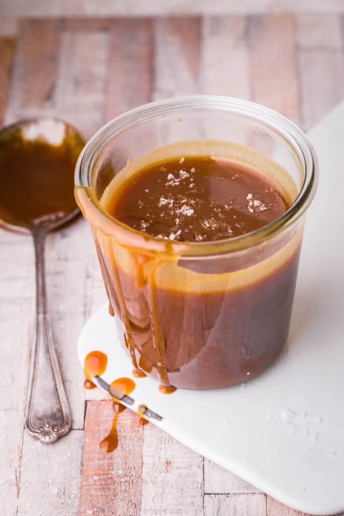 salted caramel sauce in glass jar, drizzling down jar.