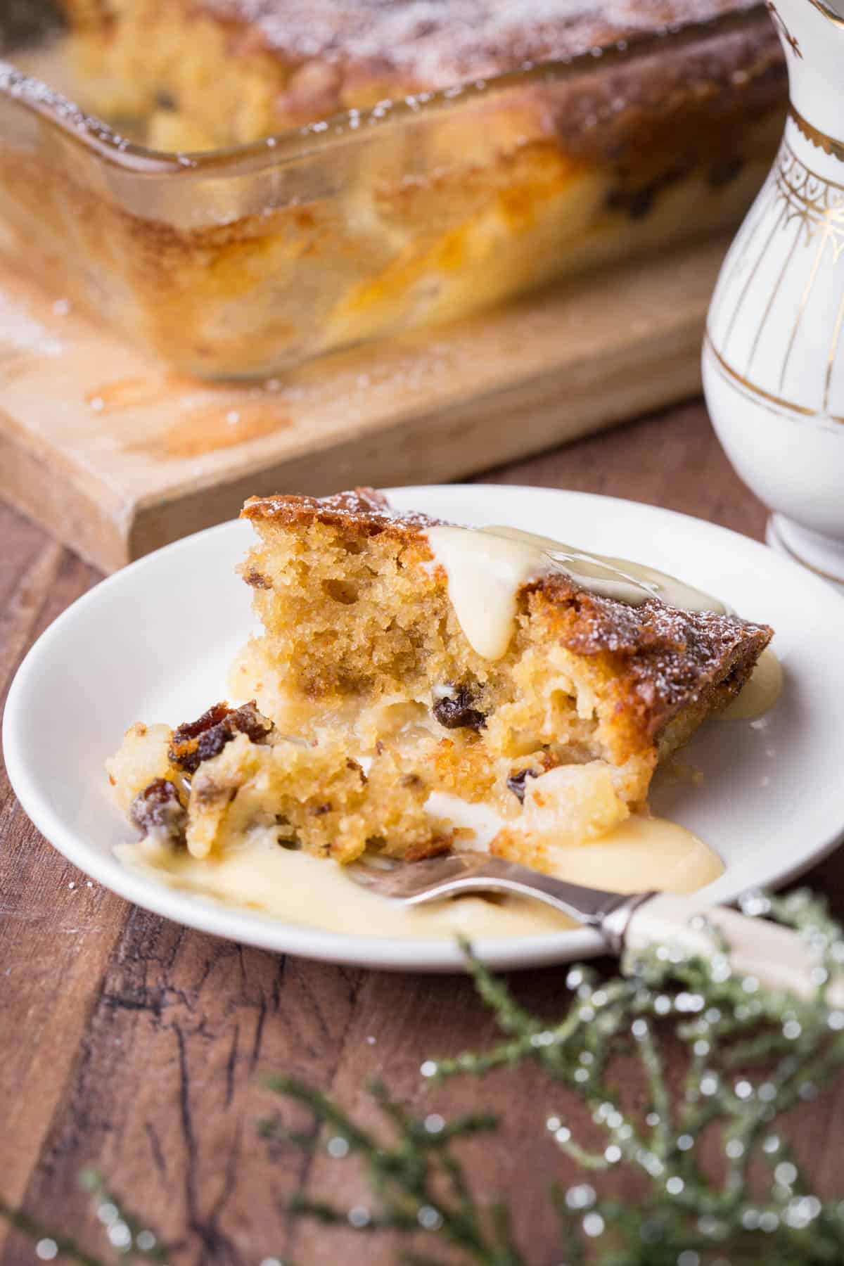 Plate of Bramley Apple Mincemeat Pudding drizzled in custard.