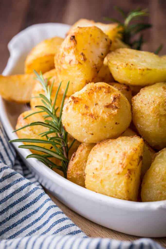 A bowl of cream baked roast potatoes, perfectly crisp and golden.