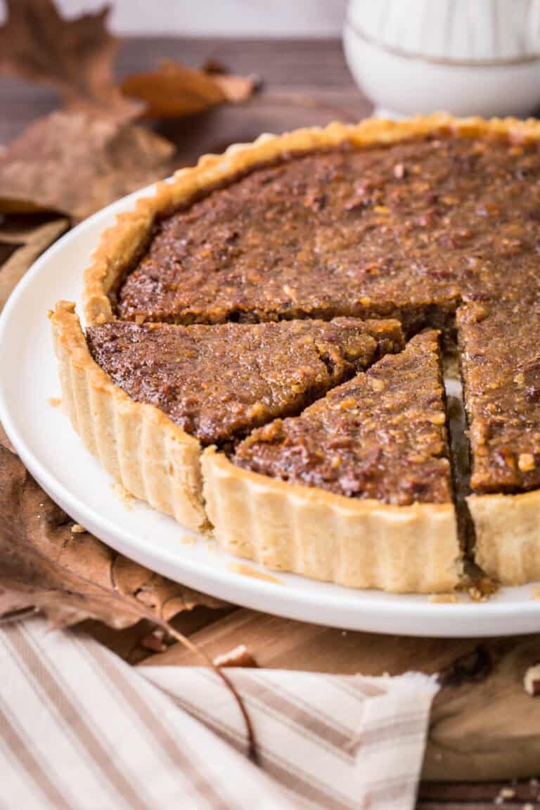 Gluten-Free Treacle Tart with Pecans on a plate with 2 slices cut.