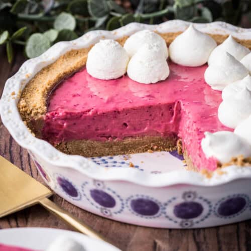 Cranberry Tart with cream piped on top next to pie slicer.