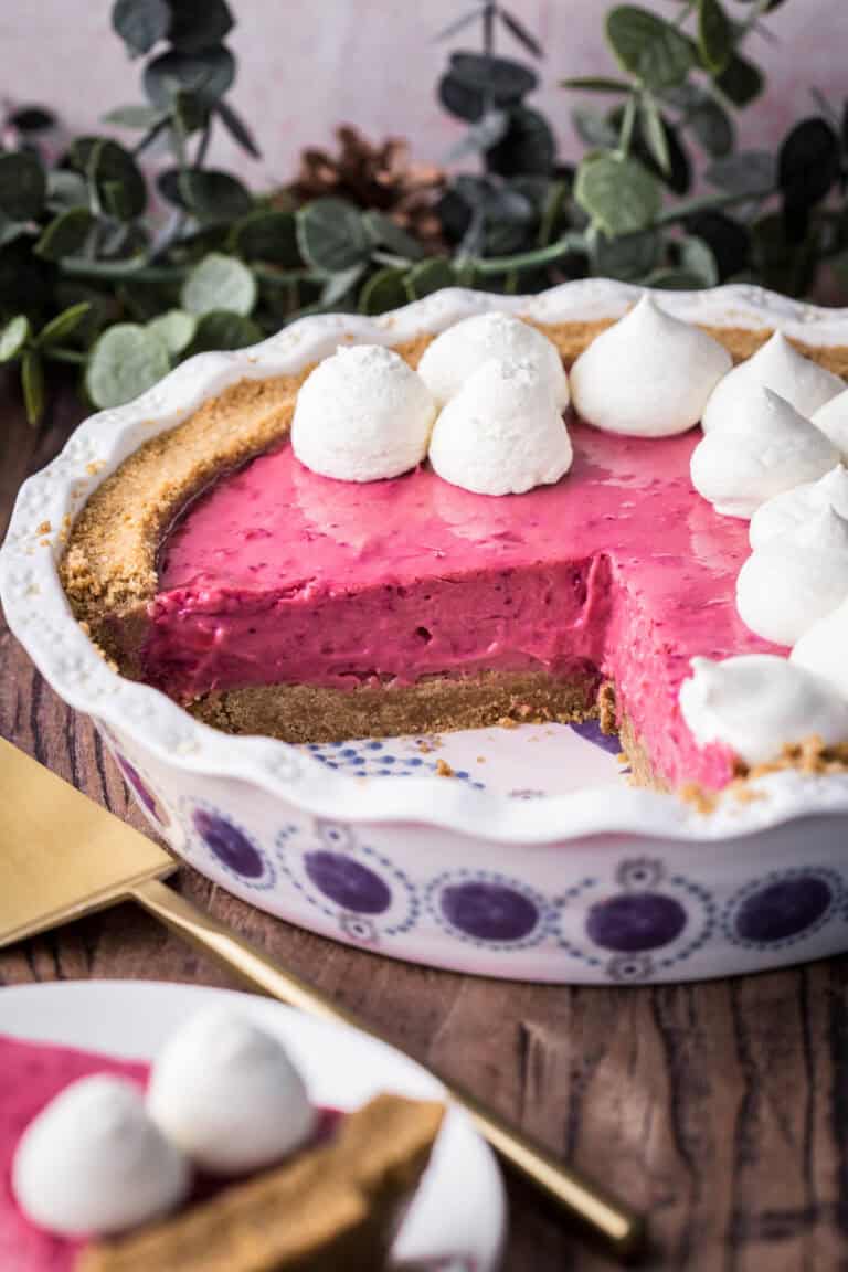 Cranberry Tart with cream piped on top next to pie slicer.