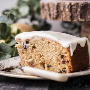 Slice of Christmas Mincemeat Cake on a plate with a fork showing fluffy inside.