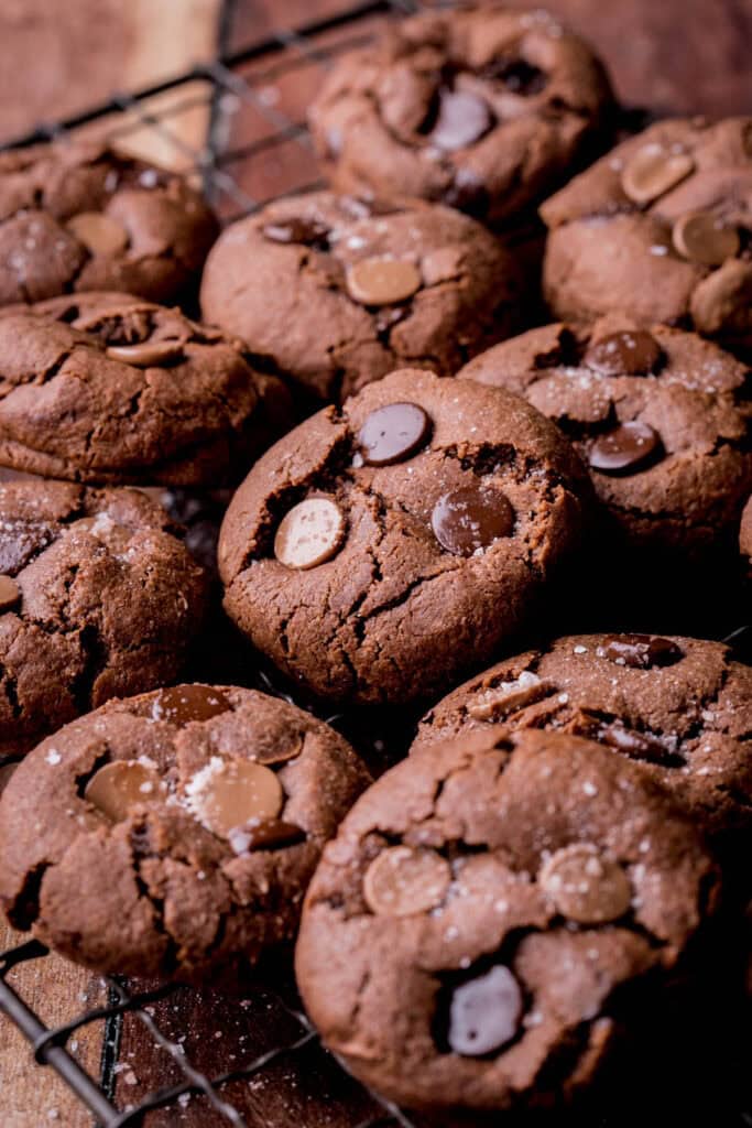 Gluten-Free Double Chocolate Chip Cookies piled on a cooling rack.