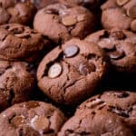 Gluten-Free Double Chocolate Chip Cookies piled on a cooling rack.