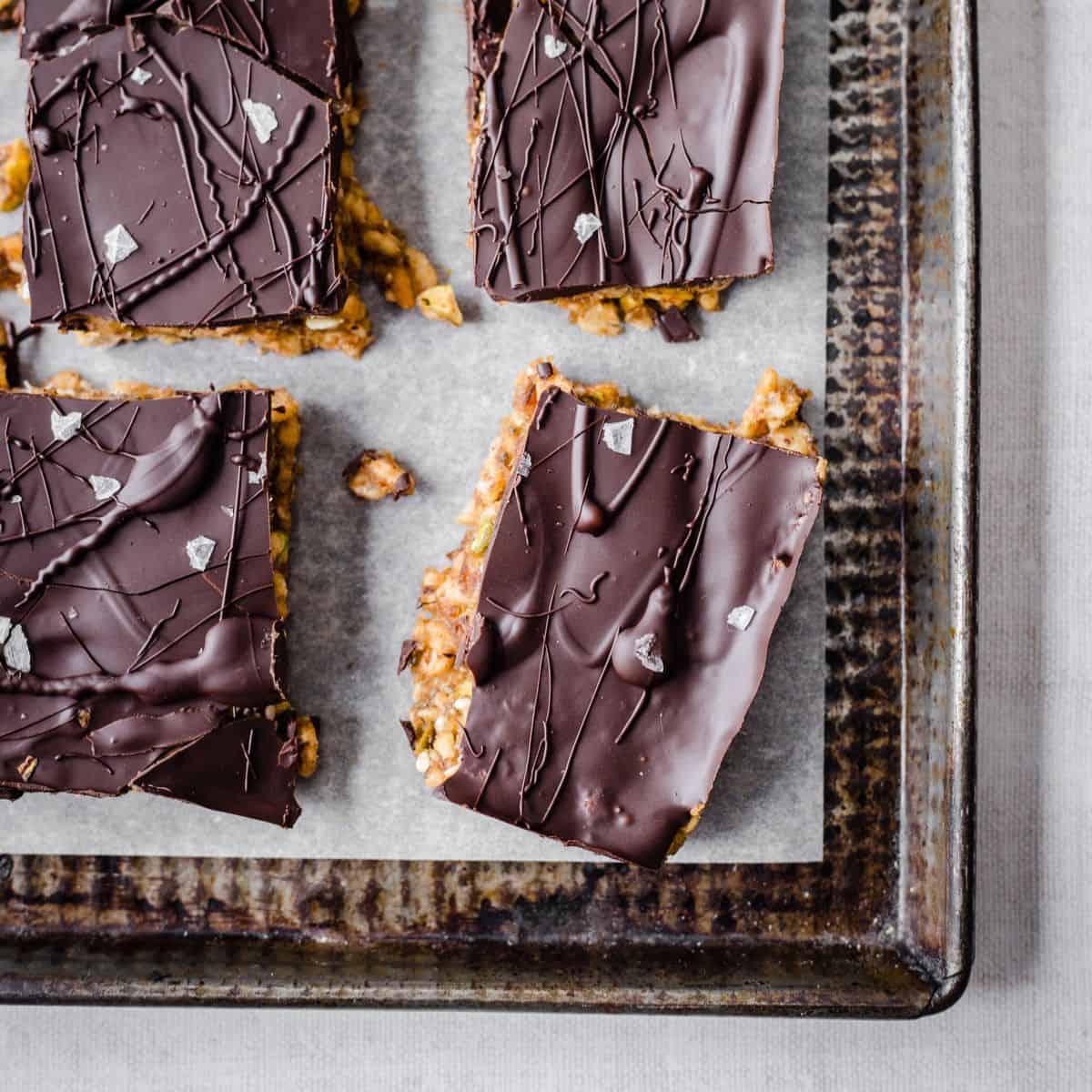 Homemade gluten-free snack bars coated in dark chocolate.
