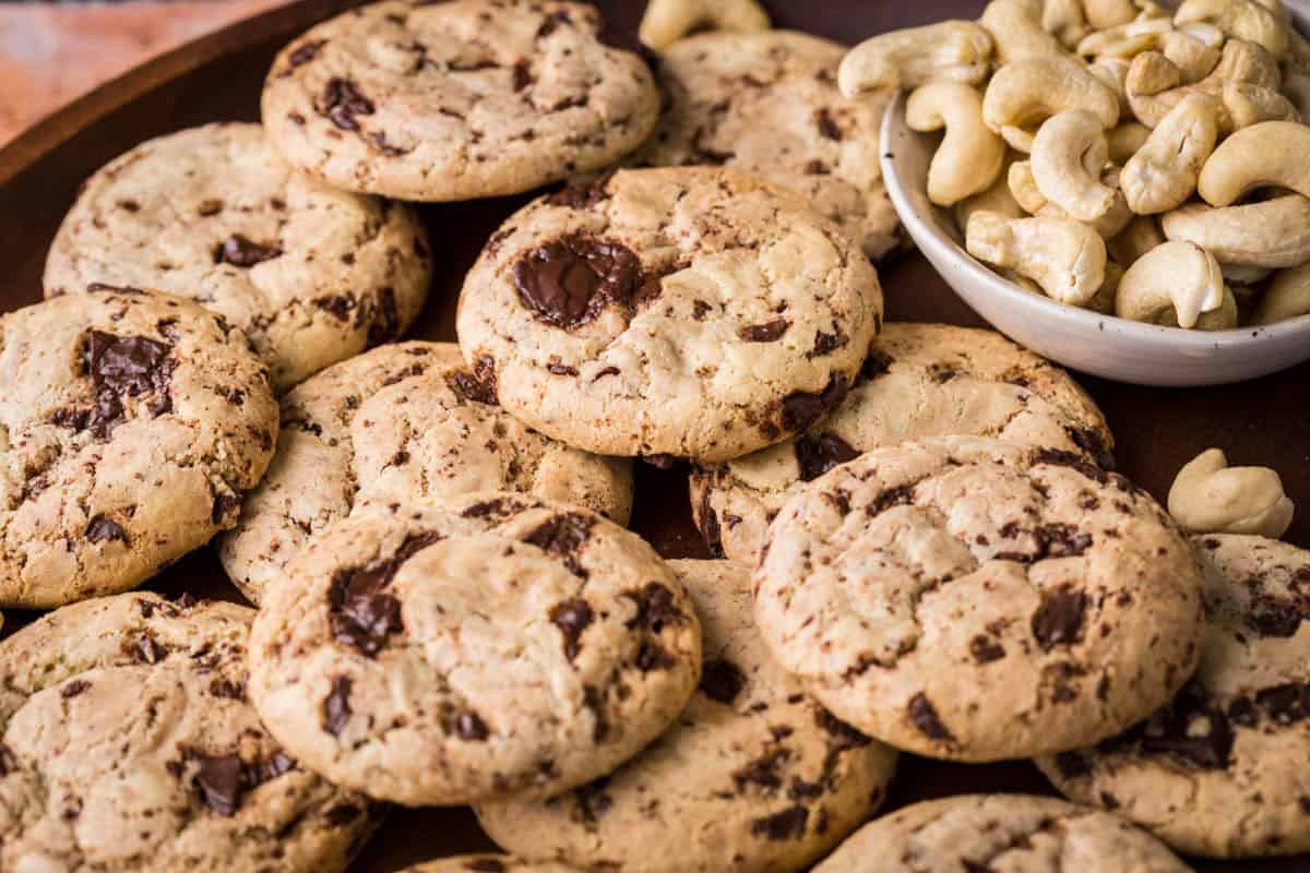 A pile of Cashew Butter Cookies with molten chocolate puddles.