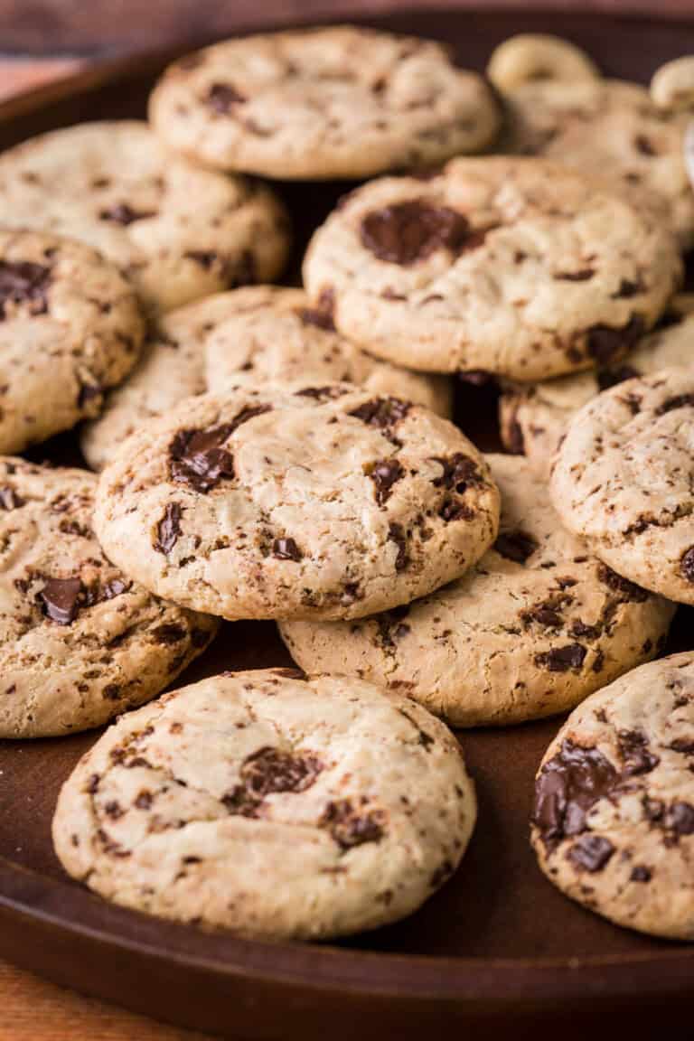A pile of Cashew Butter Cookies with molten chocolate puddles.