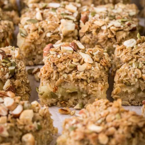 Apple flapjacks shown from the side so you can see the nutty topping, the buttery oat mixture and the fluffy bramley apple middle.
